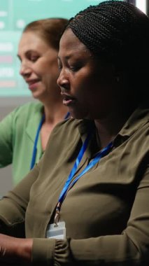 Dikey Video Afrikalı Amerikalı analist ve meslektaşları, küresel iş gelişimini kolaylaştırmak için dizüstü bilgisayardaki görüşleri gözden geçirip, yıllık veri raporlarını gece yapılan bir toplantıda inceliyorlar. Çalışma ekibi.