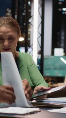 Çeşitli iş adamlarının gece geç saatlerde sessiz bir strateji odasında şirket hedeflerini tahmin etmek için raporlarını ve görüşlerini paylaştıkları dikey videoları kapat. Finans projeleri işbirliği