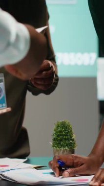 Dikey Video Çeşitliliği iş adamları gece geç saatlerde yapılan bir toplantıda fikir alışverişi ve tahmin şemaları yaparak finansal veri analizi ve iş istihbaratını gözden geçiriyorlar. Danışma kurulu işbirliği. Kamera B