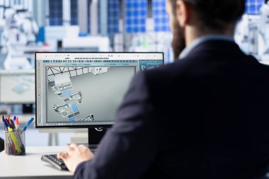 Fotovoltaik fabrikası uzmanı bilgisayar kullanarak CAD modelleri ve güneş modülleri için teknik çizimler yapıyor. İşçi verimlilik ve üretim için güneş paneli tasarımlarını geliştirmek ve optimize etmek için PC kullanır