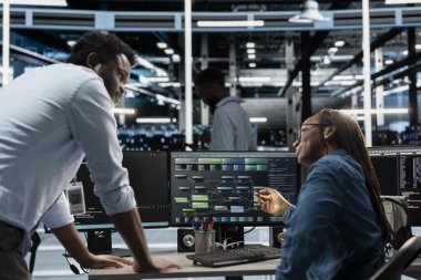 Sunucu merkezi altyapı depolama veri tabanındaki mühendis programlama tarafından yapılan denetim çalışmaları. Bilgi işlem uzmanlarının veri merkezi raflarını tamir etmelerini denetleyen Afrikalı Amerikalı takım lideri