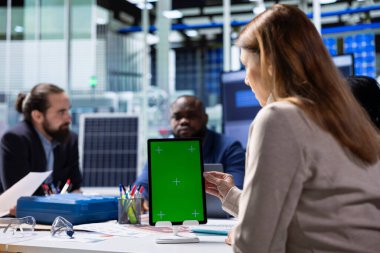 Photovoltaics fabrika çalışanları verileri analiz ediyor, sistem sağlık ölçümlerini izole ekran tableti ile gözden geçiriyorlar. Güneş panelleri, modelleme aygıtı kullanılarak teknik sorunları gideren çalışanları yerleştirir