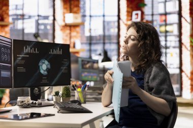 Ajans ofisindeki kadın, şirketin gelirini ve giderlerini gösteren bilgisayar ekranında finansal uygulama UI kullanıyor. Daireden çalışan kadın uzman bilgisayar kullanarak yıllık kar değerlendirmesi yapıyor..