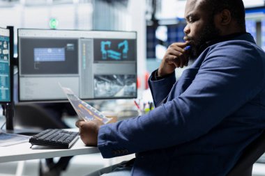 Siyahi sanayi uzmanı, yenilenebilir enerji endüstrisi için hayati önem taşıyan üretim sürecinin kalite standartlarını karşılaması için güneş paneli birimlerini bilgisayardaki kusurlar için değerlendirdi.