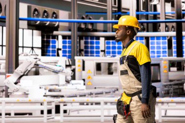 Bakım teknisyeni endüstriyel fabrikaya taşıma bantları ve robotik kollarla giriyor. Sektör 4.0 üretim tesisi dijital yenilik, özerk sistemler ve süreç optimizasyonuna odaklanıyor.