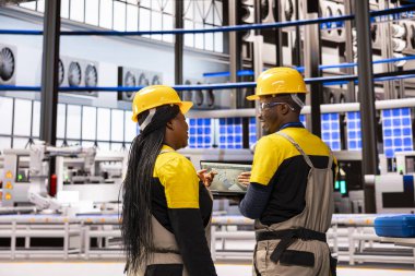 Akıllı üretim tesisi ekibi otomatikleştirilmiş fabrikayı denetliyor, montaj hattında robotik silahların etkin çalışmasını sağlıyor. Endüstri 4.0 uzmanları endüstriyel otomasyon sisteminde bakım yapıyorlar