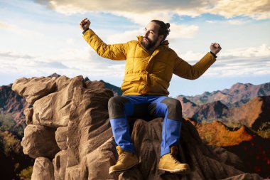Yürüyüşçü dağın tepesine ulaşır ve başarılı bir tırmanıştan sonra zafer pozu verir. Bu da maceraya olan güveni yansıtır. Gezgin korkuları yenmenin kişisel başarısının tadını çıkarıyor..
