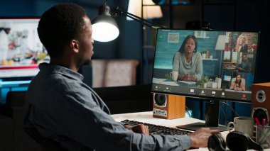 Afrika kökenli Amerikalı uzaktan kumandalı işçi oturma odasındaki bir web görüşmesine katılıyor. Gülümseyen siyah adam yurtiçi ofisteki yönetici meselelerini tartışmak için sanal iletişim kuruyor. Kamera B.