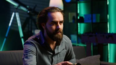 Neon ışıklı dairede dizüstü bilgisayar kullanarak TV 'de şok edici bir son dakika haberi izleyen adam. Televizyonun sesini açan kişi, dizüstü bilgisayar ve kamera A 'yı kullanarak koltukta otururken yaşanan olaylara şaşırdı.