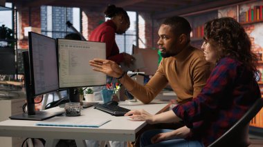 IT uzmanlarından oluşan bir ekip, uygulama geliştirmek için bilgisayardaki programlama dillerini kullanıyor. A kamerasını kodlamak için yazılım geliştirme ajansında bilgisayar kullanan takım arkadaşları.