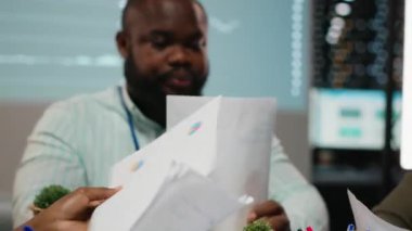 Arşivlenmiş dosyalardaki veri numaralarını değerlendiren, strateji odasında gece geç saatlerde net girişimcilik hedefleri belirlemek için raporları ve görüşleri paylaşan çeşitli uzmanları kapatın. Kamera B.