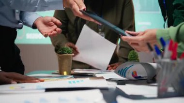 Çok ırklı grupların bir strateji odasında toplandığı saatler sonra, proje geliştirme, üretkenlik için görsel verileri, istatistikleri ve risk değerlendirme dosyalarını analiz ederek. Kamera A.