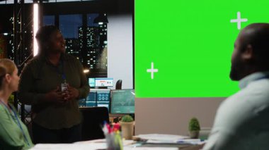 Karanlık bir ofisteki çeşitli takımlar, küresel hissedarlarla yapılan proje brifinginde şirket gündemini kesinleştirerek görüşlerini ve görüşlerini paylaşıyorlar. Mesai sonrası tartışmalar. Kamera B.