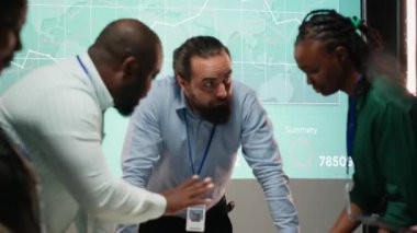 Çeşitli iş arkadaşları, proje gündemi planlamasını güvence altına almak için çalışma saatleri dışında yapılan bir iş toplantısına dosyalar, bilgi alışverişi ve performans göstergeleri için katılıyor. Geç saate kadar brifing. Kamera B.