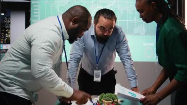 Çeşitli iş arkadaşları, proje gündemi planlamasını güvence altına almak için çalışma saatleri dışında yapılan bir iş toplantısına dosyalar, bilgi alışverişi ve performans göstergeleri için katılıyor. Geç saate kadar brifing. Kamera A.