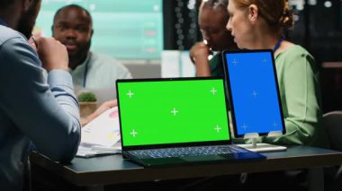 Çok ırklı analistler, bir şirket firmasında çalışma saatleri dışında fotokopi alanlarıyla iş birliği yaparak güncellemeleri tartışıyor ve belgeleri değiş tokuş ediyorlar. Gelişme sonuçlarını tahmin etmek için şemalar. Kamera B.