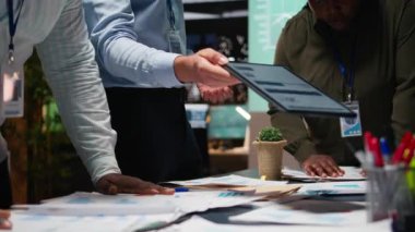 Takım çalışmasıyla ilgili bir brifinge katılan iş arkadaşları, belge alışverişi ve mali güncellemeleri gözden geçiriyorlar. Sorunları çözerek hedefleri hizalamak. Kamera A.