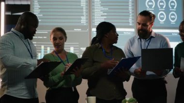 Gece geç saatlerde işbirliği yapan çok ırklı iş adamlarının portresi, karanlık bir ofiste toplanmak ve girişim geliştirme üzerinde çalışmak. Danışma kurulu içinde çeşitlilik. Kamera B.