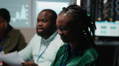 Siyahi yönetici yardımcısı sermaye fonlarını ve toplantıdaki raporlara ilişkin gelir verilerini izliyor, kâr artışı ve bir proje için bütçe tahsisini gözden geçiriyor. Bilgilendirici gece oturumu. Kamera B.