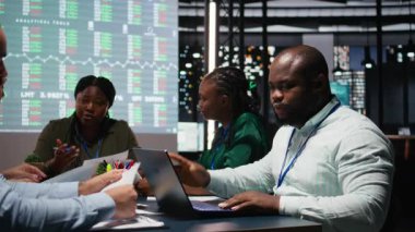 Kara Müdür ve ekibi gece geç saatlerde yapılan toplantı sırasında yıllık veri raporlarını inceleyerek, yönetim kurulundaki küresel iş gelişimini kolaylaştırmak için pazar arzı ve talepleri araştırdılar. Kamera A.