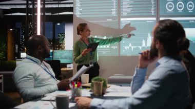 İş ortakları gece toplantılarında aylık veri raporlarını inceliyor, performansı sağlamak için iç iletişim stratejileri geliştiriyor. Çeşitli takımlar çok uluslu bir şirketi genişletiyor. Kamera A.