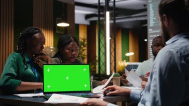 Tecrit edilmiş bir bilgisayar, strateji geliştirme ve proje gündemi için hedefler belirleme ile geç bir danışma kurulu toplantısına katılan çeşitli meslektaşlar. Uzmanlar şirket genelindeki güncellemeleri gözden geçiriyorlar. Kamera A.