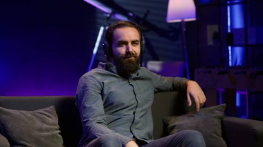 Oyuncu, video oyunu seviyesini kazandıktan sonra heyecandan bağırarak sevinçten havalara uçuyor. Oyun konsolunda oynarken zafer kazandıktan sonra sevinçten bağıran kendinden geçmiş adam, kamera A