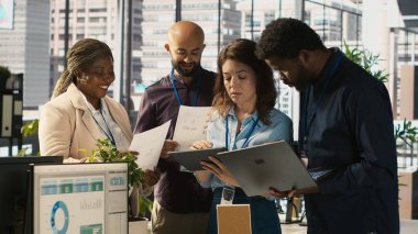 Ofisteki iş arkadaşları beyin fırtınası yapıyor, finansal tabloları inceliyor, iş performans ölçümlerini inceliyor. İş yerinde çalışan iş arkadaşları sohbet ediyor, veri eğilimlerini inceliyor, kamera A