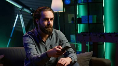 Sıkıcı insan TV karşısında kanepede abonelik temelli yayın yapan uzaktan kumandayla gezinen. Yorgun adam TV 'de VOD programları izliyor, kanalları, kamera A' yı çekiyor.