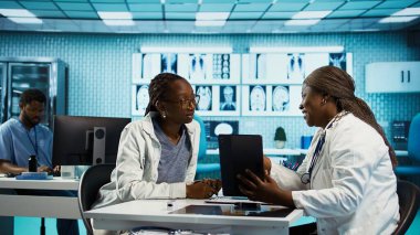 Klinik taramalar ve kayıtlar kullanan kadın doktor rutin kontroller sırasında bir hastaya tavsiye veriyor, tedavi ve tıbbi uzmanlığa odaklanıyor. Uzman uzman genç bir kıza tavsiye veriyor. Kamera B.