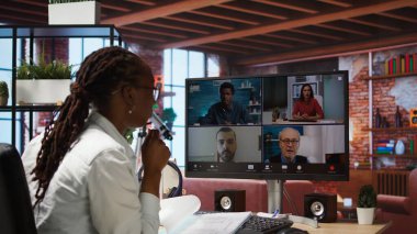 Uzaktan kumandalı ofis çalışanı internet video görüşmesi sırasında iş arkadaşlarını selamlıyor, bilgisayar monitörüne bakıyor. İş yerinde telgraf işçisi el sallıyor, telekonferans sırasında ekip üyelerini selamlıyor, kamera A