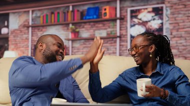 Siyah çift, uzun bir günün ardından kanepede sıcak içkilerle kaynaşıyor. Gülümseyen adam ve kadın rahat bir ortamda rahatlıyor, arkadaşlığın güzelliği ve huzurlu bir rahatlama. Kamera B.