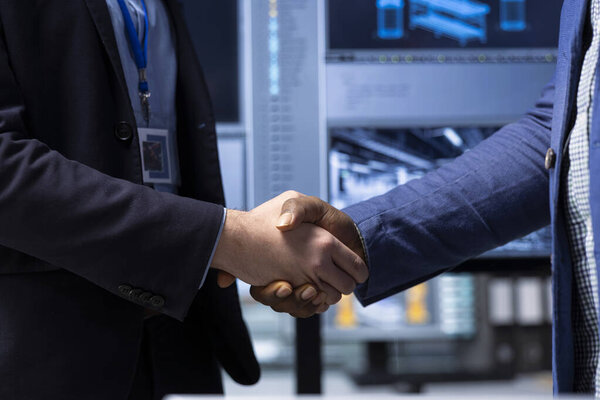 Shareholders in industrial plant do handshake, closing deal after factoring in growth scenarios and forecasting returns. Investors shaking hands with factory management after analyzing revenue streams