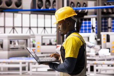 Endüstriyel teknisyen otomatik üretim hattını robot silahlar ve dijital sistemlerle yönetiyor. Akıllı üretim fabrikası yenilikçi üretim için sürekli bakım ve otomasyon hizmeti sunar..