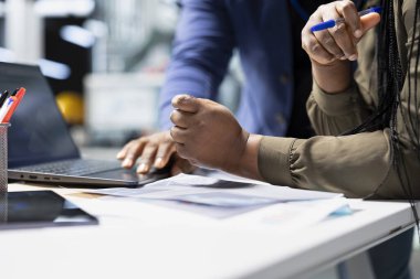 Afrikalı Amerikalı mühendisler endüstriyel iş arkadaşları güneş panelleri için üretim hattı üzerinde takım çalışması yapıyorlar, teknik içgörü ve takım çalışmasını birleştirerek temiz enerji altyapısını ilerletmek için.