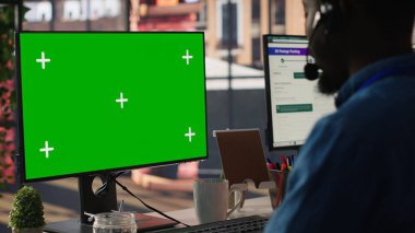 Çağrı merkezinde teknik destek uzmanı yeşil ekran bilgisayar kullanarak sorun çözüyor. IT çalışanı, müşteri bağlantı sorunlarını krom anahtarlı PC, kamera A kullanarak çözüyor.