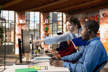 Müşteri hizmetleri müdürü yeni işçiye bilgisayardaki özel şirket yazılımında destek biletlerini nasıl takip edeceğini öğretiyor. Çağrı merkezi amiri Afrikalı Amerikalı stajyere nasıl destek biletleri oluşturulacağını gösteriyor.