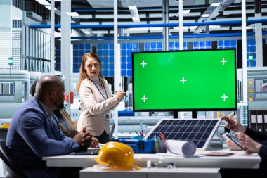 Fotovoltaik fabrikası yöneticisi hissedarlara veri göstermek için krom anahtar ekranı kullanır. Güneş panelleri fabrika yöneticisi izole ekran monitörü kullanarak yatırımcılara teknoloji görüşleri sunar