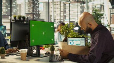 Çalışan, müşteri görevlendirme projesindeki ilerlemeyi kontrol etmek için izole ekran bilgisayarı kullanıyor. Denetimden sonra evrak işleri ile ilgili veri istatistiklerini okuyan model bilgisayarın önündeki ofis görevlisi, kamera B