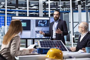 Photovoltaics fabrikası yöneticileri stratejik yatırım kararları planlıyorlar, verileri gözden geçiriyorlar. Yatırımcı ve güneş panelleri fabrika yönetim ekibi birlikte iş verilerini tartışıyor