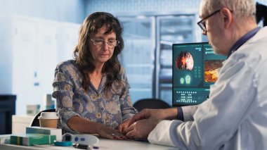 Sağlık uzmanı, hastalarla rutin kontroller sırasında hayati belirtileri kontrol ederek dolapta oksijen doygunluğu ölçümü yapıyor. Doktor, doğru konsültasyon okumaları için oksimetre kullanıyor. Kamera B.