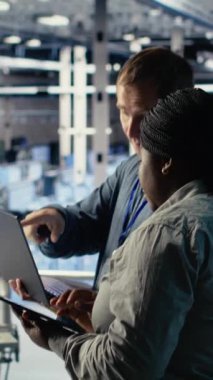 Sunucu odasında birlikte çalışan dikey video teknisyenleri, yapay zeka sistemlerinin görevlerini en iyi şekilde yapmalarını sağlıyorlar. Veri Merkezi çalışanları yapay zeka modelini ayarlamak için beyin fırtınası yapıyorlar