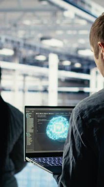 Dikey Veri Merkezi sistem yöneticileri, en uygun fonksiyona göre ayarlanan nöral ağların yapılandırılmasını araştırıyorlar. Sunucu merkezi çalışanları, derin öğrenme hatası raporlarını kontrol etmek için laptop kullanır, kamera