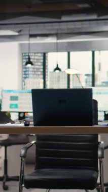 Bir dizüstü bilgisayar ve performans raporlarıyla donatılmış dikey video sessiz şirket alanı, veri odaklı karar verme, tahmin ve stratejik analizler için hazır modern bir iş ofisini temsil etmektedir..