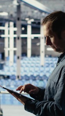 Dikey video Veri Merkezi teknisyeni makine öğrenme sürecini tabletle izleyip işlevsel ölçümleri gözden geçiriyor. Teftiş sırasında sinirsel ağ raporlarını incelemek için aygıt kullanan bilişim uzmanı, kamera B