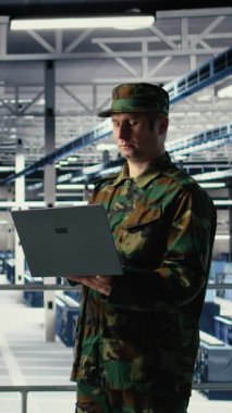 Sunucu odasındaki dikey video askeri ve mühendis bilgisayar sistemlerini yönetmek için yapay zeka araçları kullanıyor. Ordu komutanı ve kadın programcı sunucudaki yapay zekayı kullanarak bilgileri gözden geçirir