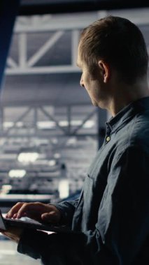 Endüstriyel platformdaki dikey video veri merkezi yönetimi Al 'ın kontrol panelini dizüstü bilgisayarla kontrol ediyor. Sunucu çiftliğindeki adam güvenilir performans sağlamak için yapay zeka araçlarını not defterinde test ediyor. Kamera B