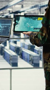 Ordu generali ve veri merkezindeki iş arkadaşının füze takibi için yapay zekayı radar sistemlerine entegre ettiği dikey video. Sunucu merkezinde çalışan asker ve teknisyen hava hareketlerini analiz ediyor.