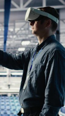 VR kulaklık takarak sunucu odasında dikey video programcısı derin öğrenme sistemlerini optimize ederek görevleri yerine getiriyor. Sanal gerçeklik kullanarak yapay zeka modelini ayarlayan veri merkezi bilişim uzmanı, kamera B