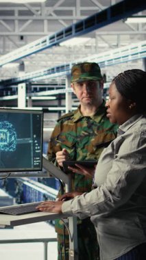Sunucu odasındaki dikey video ordu uzmanları keşif bilgilerini incelemek için gelişmiş yapay zeka araçları kullanıyorlar. Askeri veri merkezi personeli görev hazırlıklarına yardımcı olmak için yapay zeka sistemlerini çalıştırıyor
